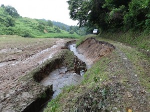 農作業道崩落、左側は大豆転作田、沢からの濁流で冠水