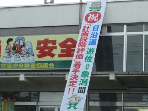 日沿道秋田県境部分計画段階評価決定を祝う遊佐町役場の看板