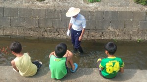 郡鏡コミ振「水の旅」行事の魚つかみ大会を待つ子供たち